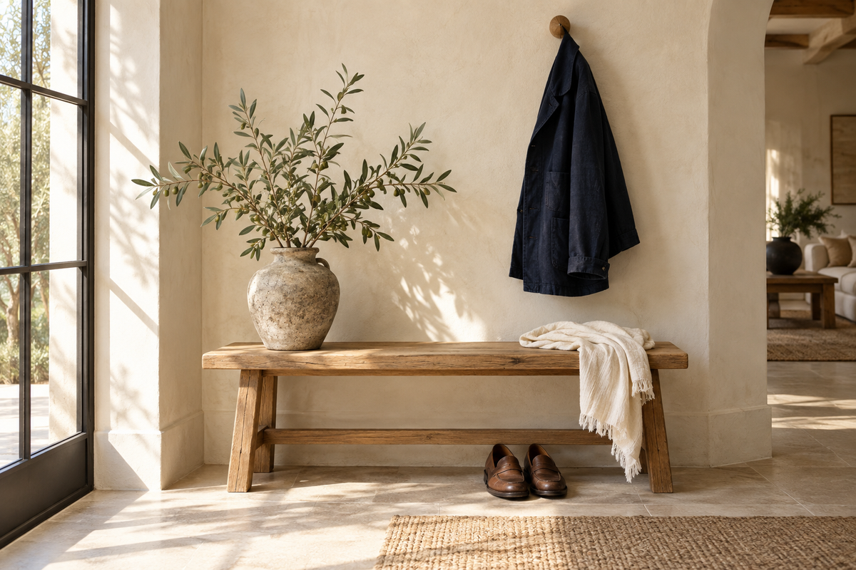 Sunlit entryway with a navy jacket, ivory scarf and natural oak bench